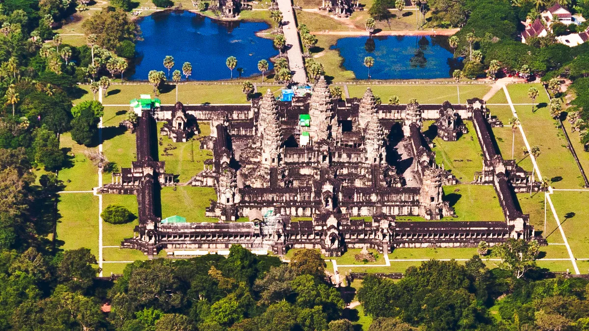 Aerial view of the Angkor Wat temple complex surrounded by water and forest