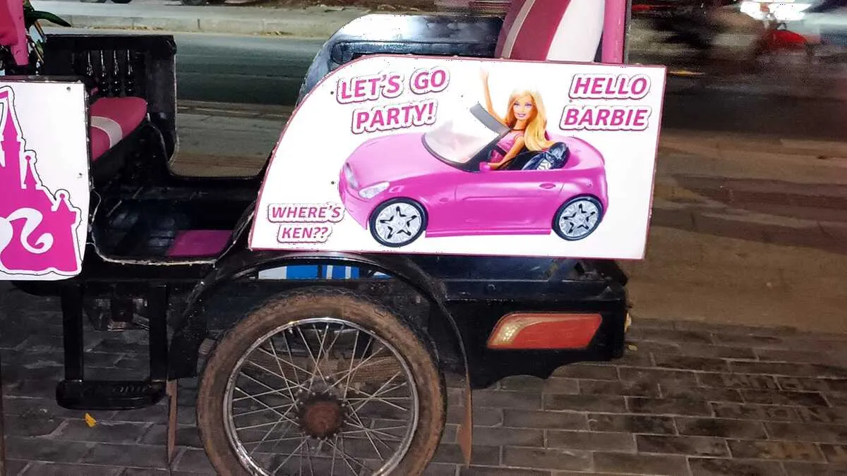 Bright pink tuk-tuk parked on a street in Siem Reap